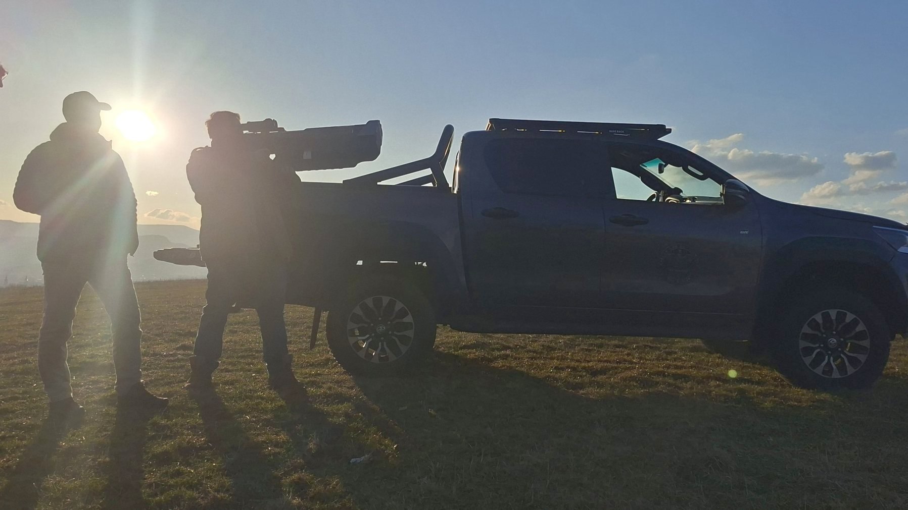 Operator holding the ADP anti-drone rifle beside a support vehicle at dusk